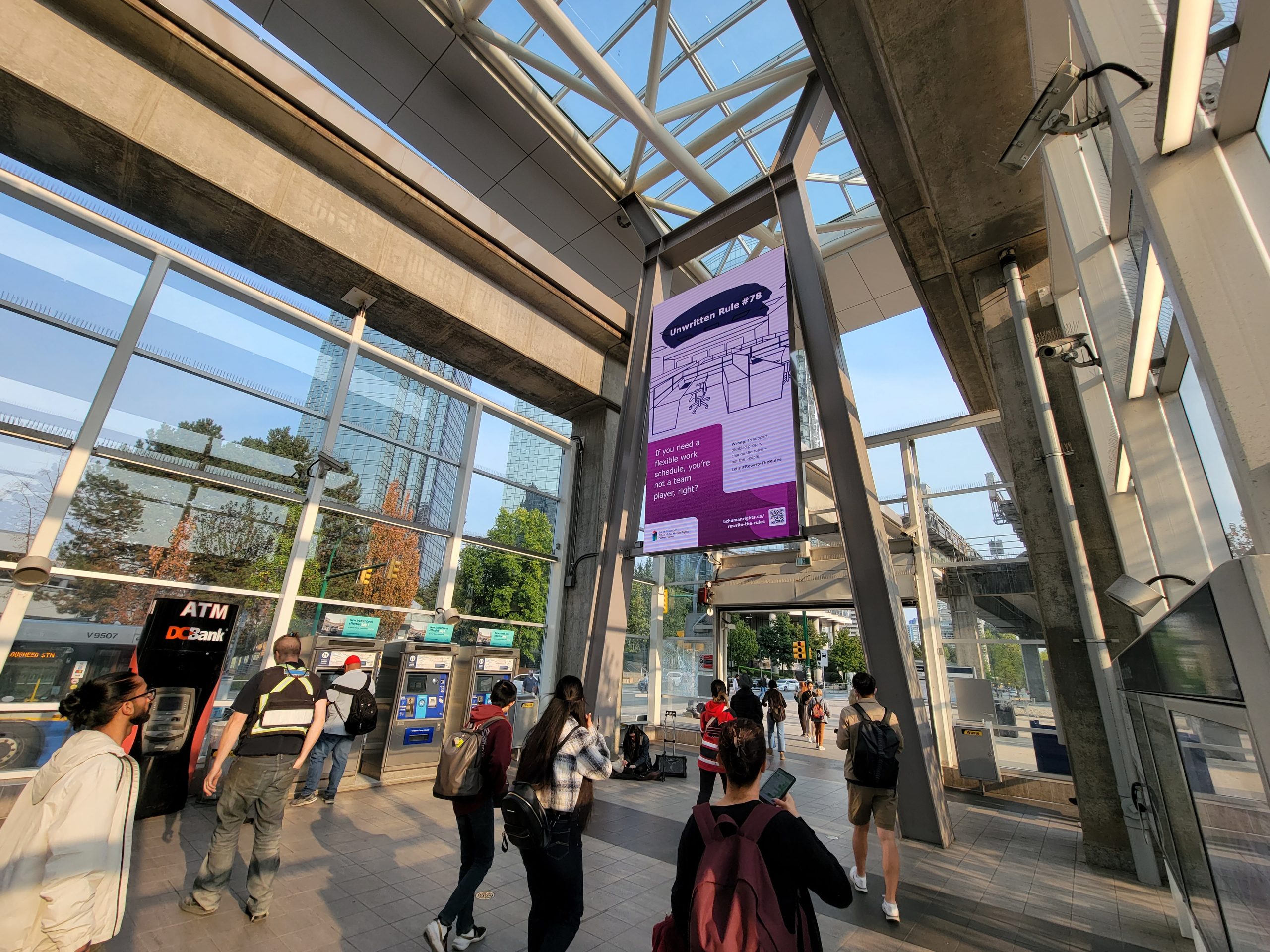 Photo of #RewriteTheRules digital banner in Metrotown Skytrain station