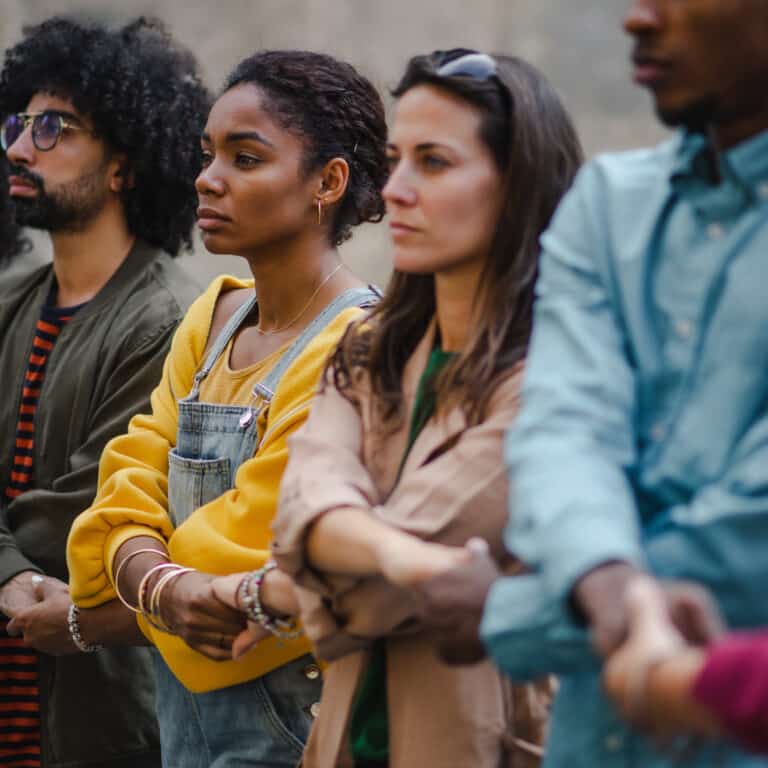 Group of activists crossing their arms and holding hands in a line to create a barrier
