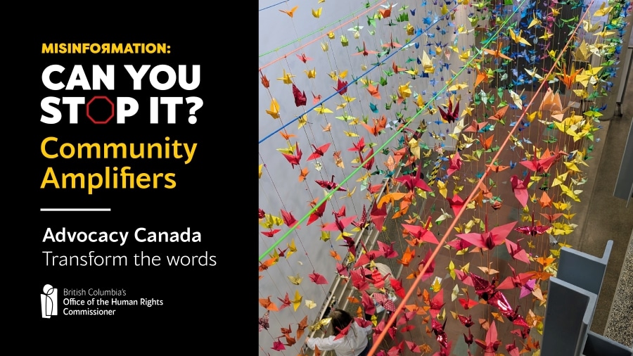 Hundreds of rainbow coloured origami cranes hang down into a hall space creating a rainbow of colour.